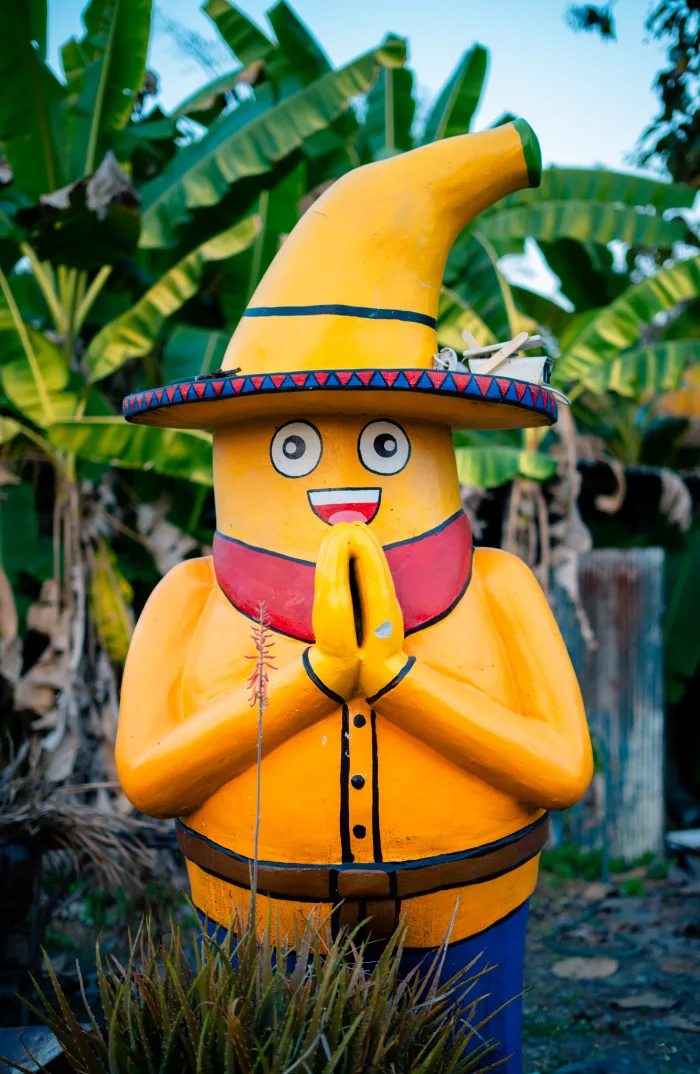 A cheerful Thai welcome statue in the campus garden