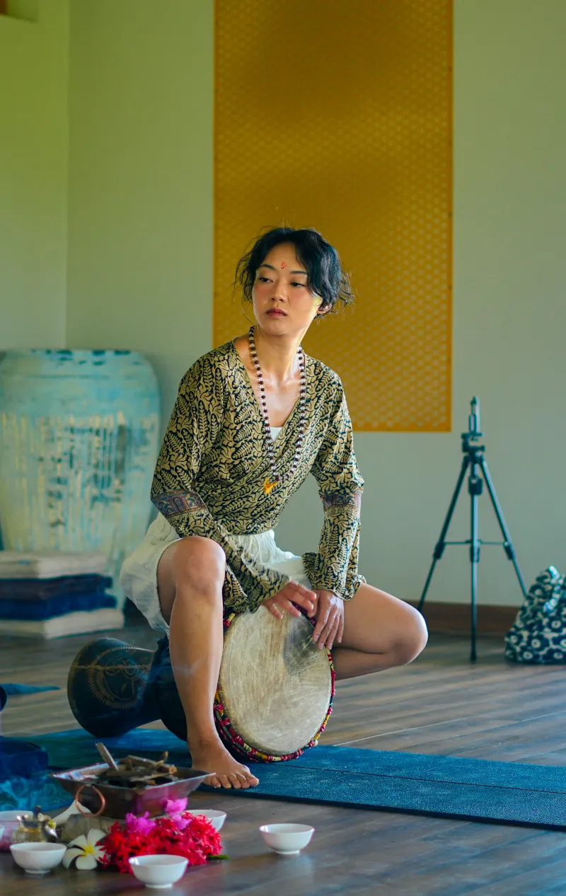 A teacher with a djembe drum during a healing session