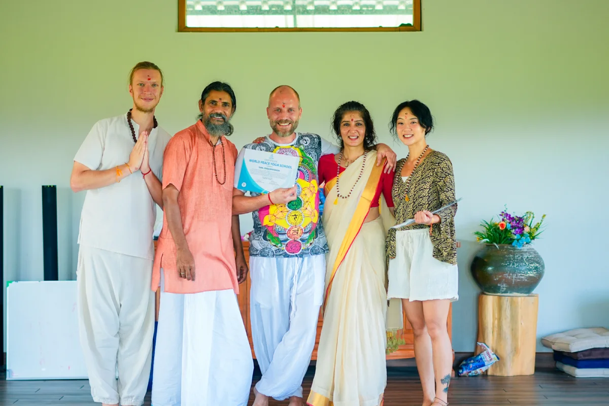 A graduate holding a certificate with teachers at the Chiang Mai school