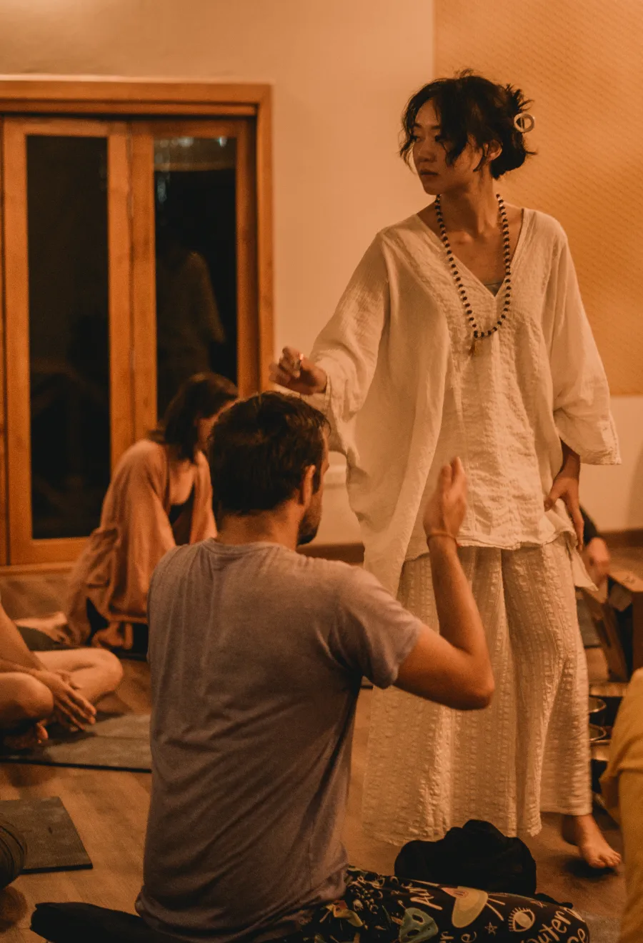 A teacher guiding students during a sound healing class