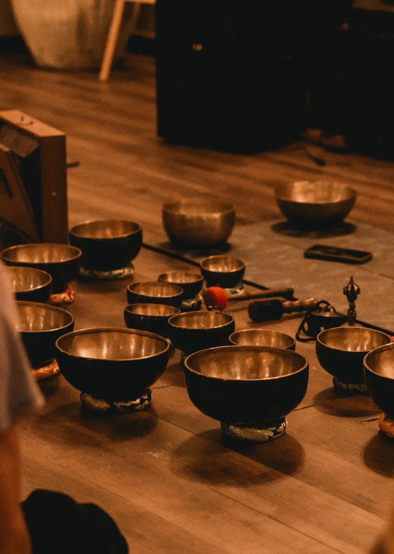 Rows of Tibetan singing bowls set out for a sound bath