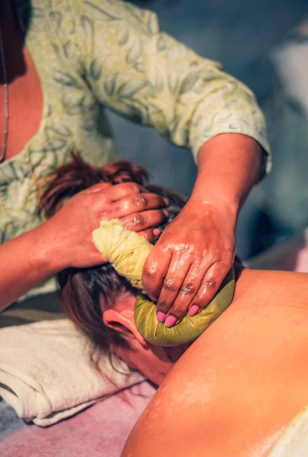A therapist giving a Kizhi herbal poultice massage