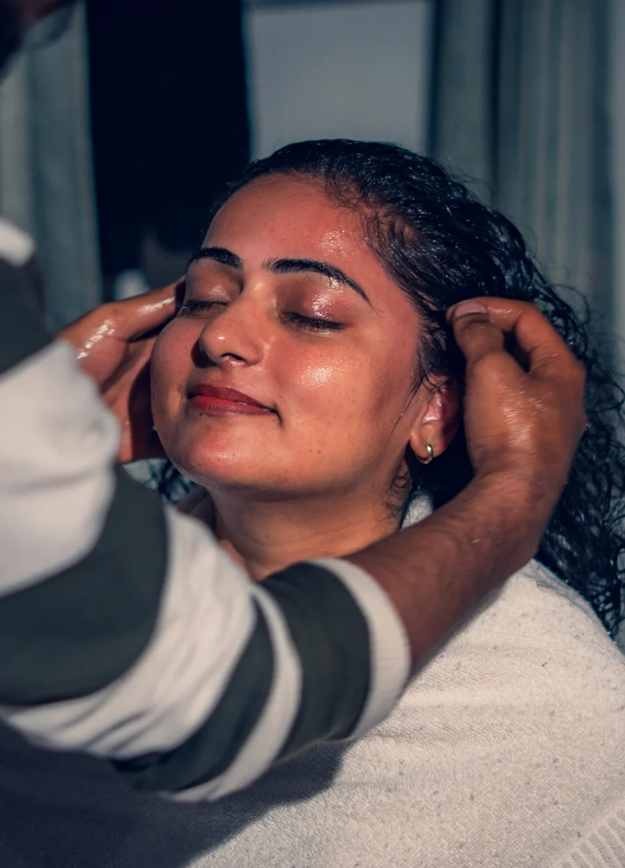 A therapist giving an oil head and face massage