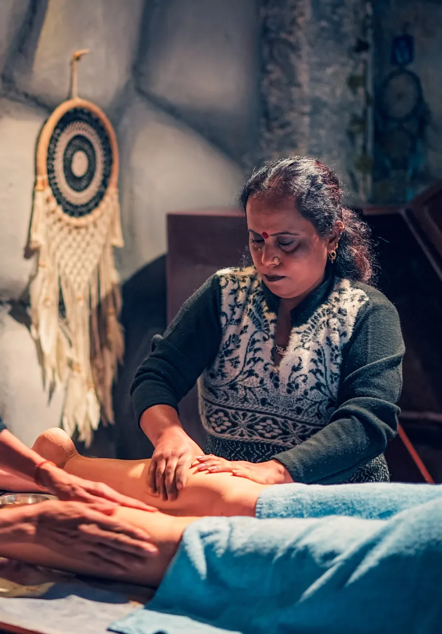 An Ayurvedic therapist giving a leg massage