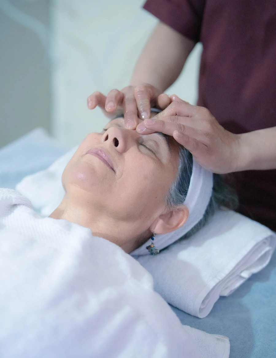 A therapist giving a gentle face and forehead massage