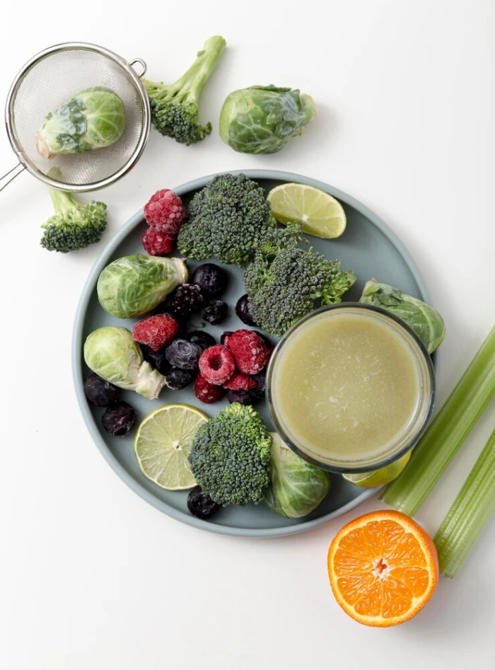 A plate of greens, berries and a detox juice